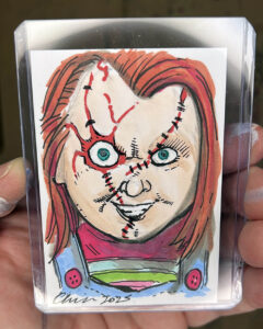 Drawing of the character Chucky, from the movie "Child's Play" on a sketch card.